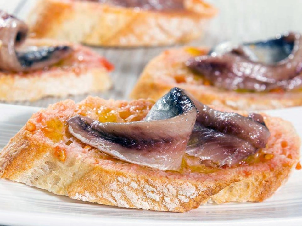 Anchoa de L'Escala sobre una rebanada de pan con tomate